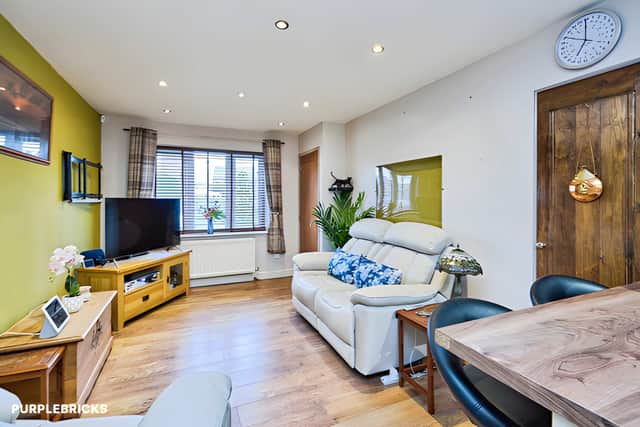 Wood-effect flooring runs through the open-plan living and dining area, creating a connected space for relaxing and entertaining.