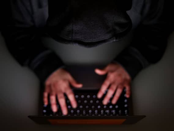 A laptop user with their hood up
