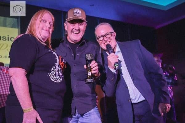 Dan Jones performing at the UK Country Music Awards in Derby, pictured with Allan Watkiss of UK Country Radio, where his song "One More Whiskey for the Road" won Song of the Year.