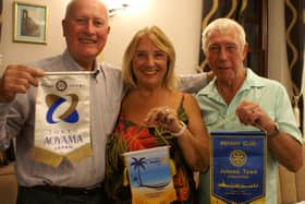 Exchanging banners from left to right Rotarian Gareth Watkins and Rotarians Lynne and John Lathbury from Thailand. 