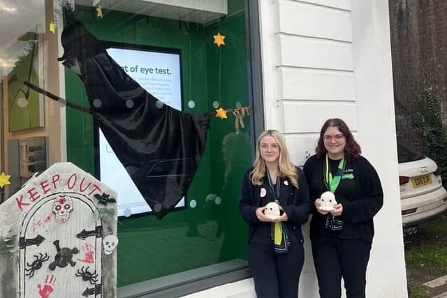 Mia and Katie outside Specsavers Shifnal with its Halloween window decorations