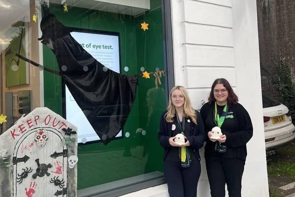 Mia and Katie outside Specsavers Shifnal with its Halloween window decorations