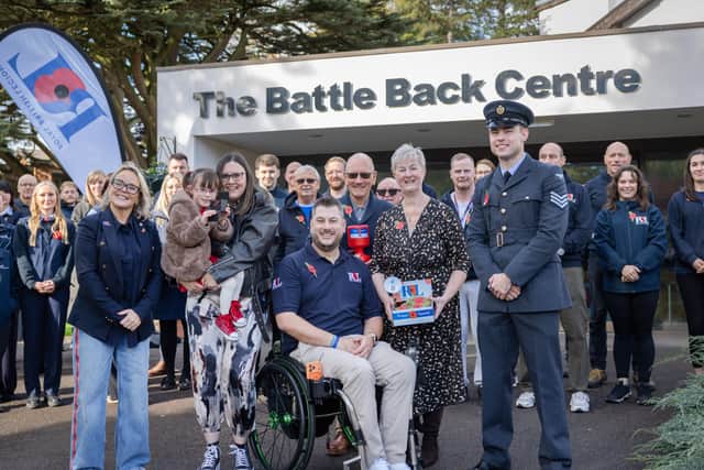 Sergeant Cameron Lewis, 25, RAF, Air Traffic Controller based at RAF Odiham presents a poppy to Neil Fellingham, RAF veteran and Team UK Invictus Games 2025 alumnus, his wife, Lauren, their daughter Poppy, 5 and Neil's parents