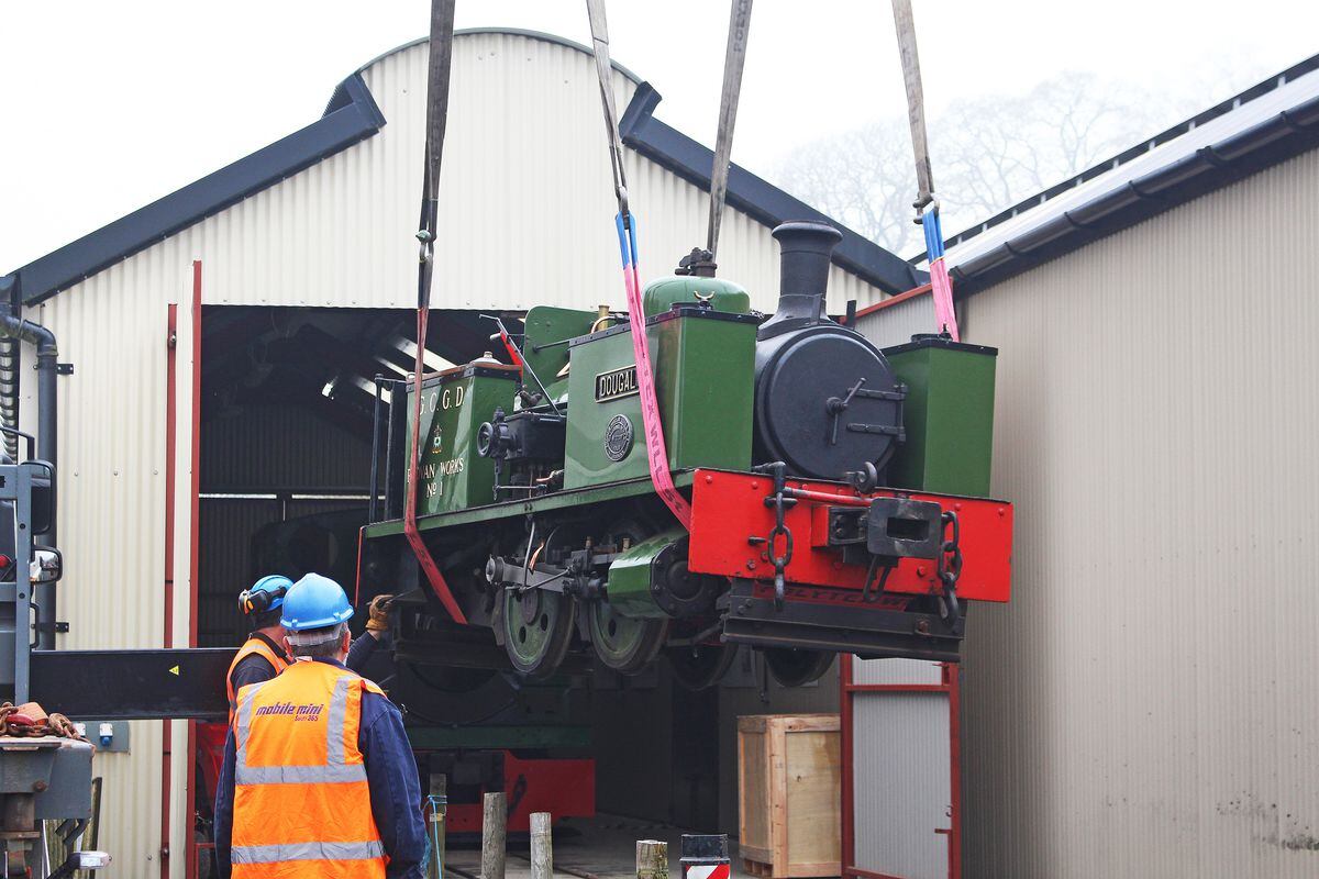 Douglas being craned back into his shed