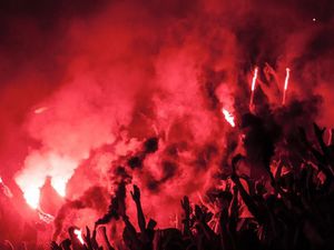Football fans holding flares