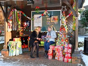 Clare Pitchford and Mary Jones, who have helped create a crochet Christmas living room in a bus shelter