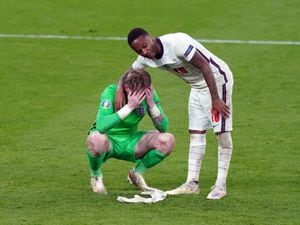 England goalkeeper Jordan Pickford stands dejected with Raheem Sterling