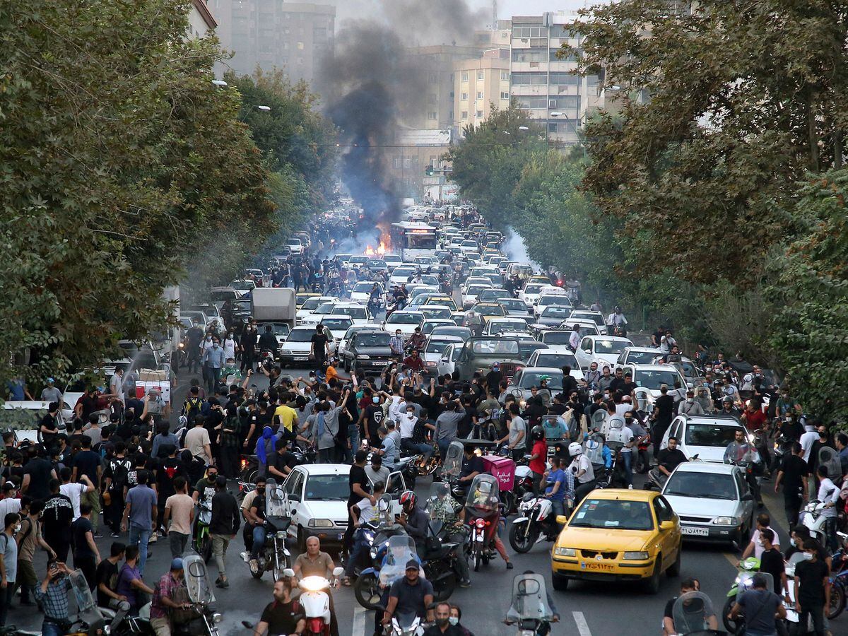Protesters chant slogans during a protest over the death of a woman who was detained by the morality police, in downtown Tehran, Iran