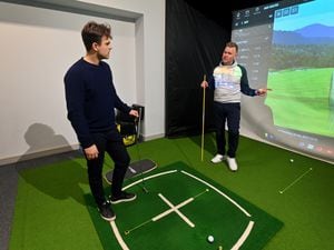 Reporter Ollie Westbury is given tips on his golf swing by golf academy director Rob Bluck, at Three Hammers Golf Complex, Wolverhampton