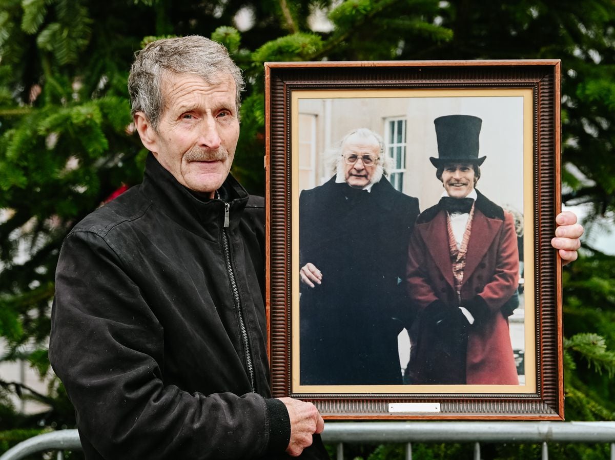 Kim Downer holding a a picture of himself and George C. Scott outside the old Royal Salop Infirmary.