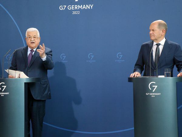 Palestinian President Mahmoud Abbas, left, speaks during a news conference after a meeting with German Chancellor Olaf Scholz, right, at the Chancellery in Berlin