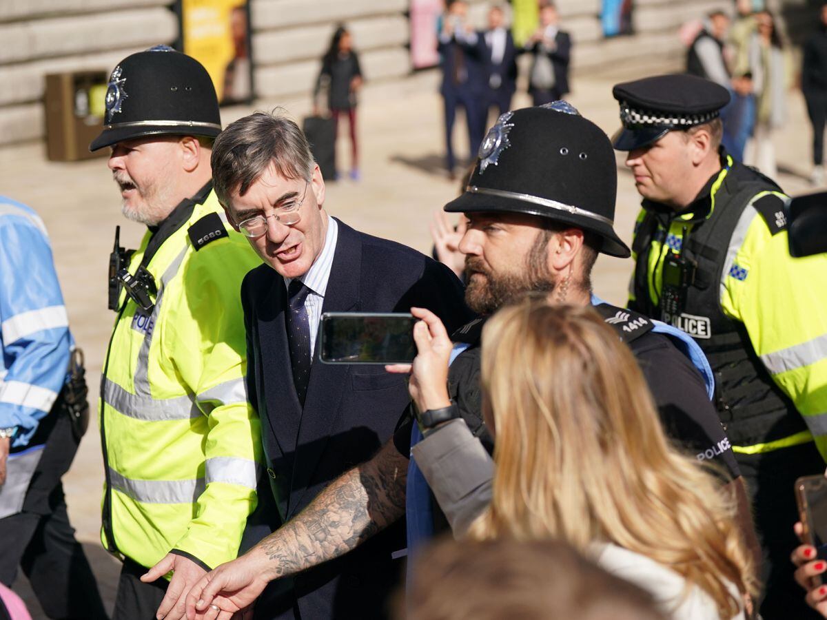 Jacob Rees-Mogg surrounded by police officers