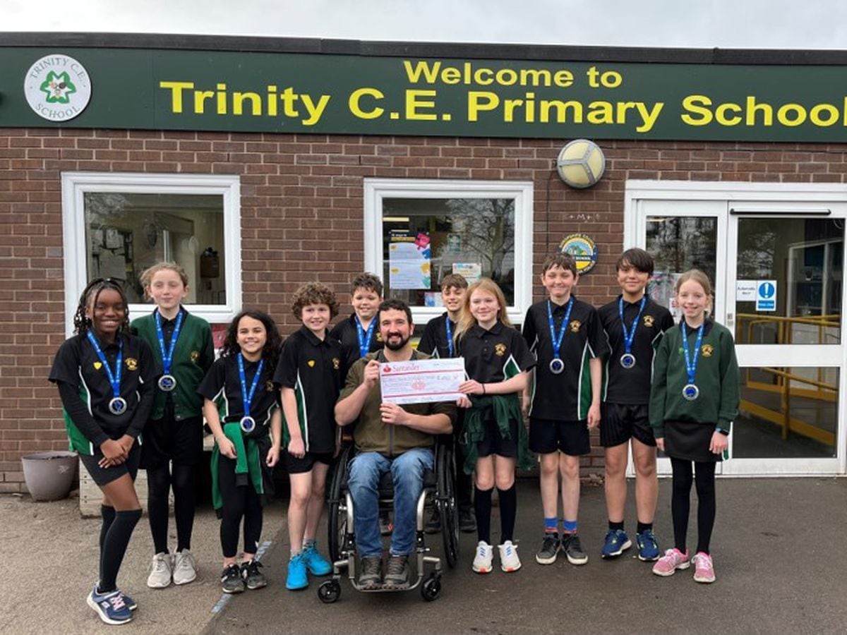 Pupils at the school hand over their cheque to disabled adventurer Darren Edwards