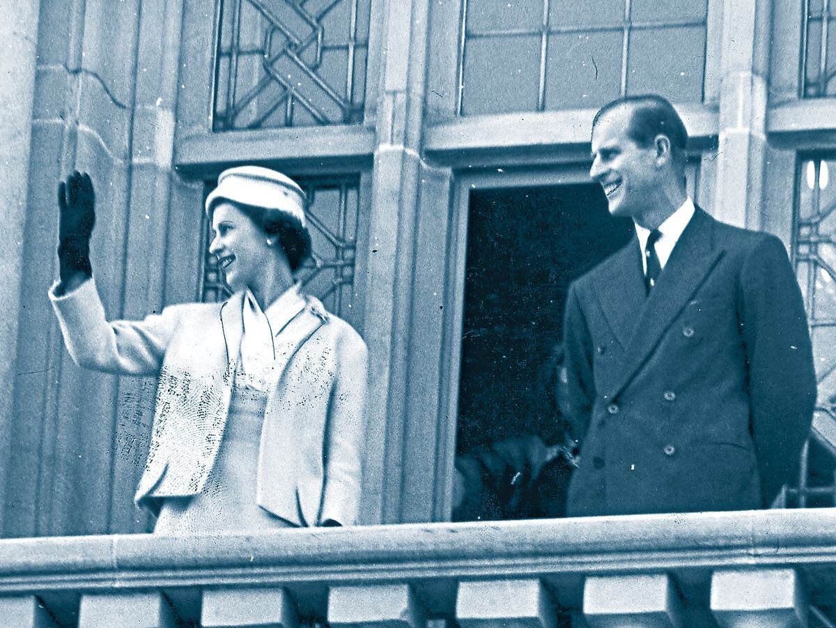 Her Royal Highness waves to crowds as she appears on the civic balcony during a visit to Dudley in 1957