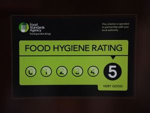 A Food Standards Agency rating sticker on a window of a restaurant. 