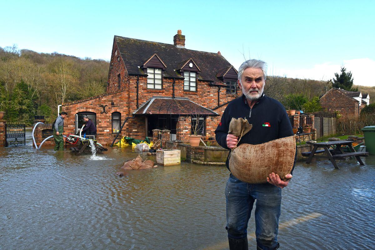 Away from the flood barriers in Coalford, Ironbridge, Colin Meredith helps his neighbours after having to abandon his cottage for the third time in three years. Photo: Dave Bagnall