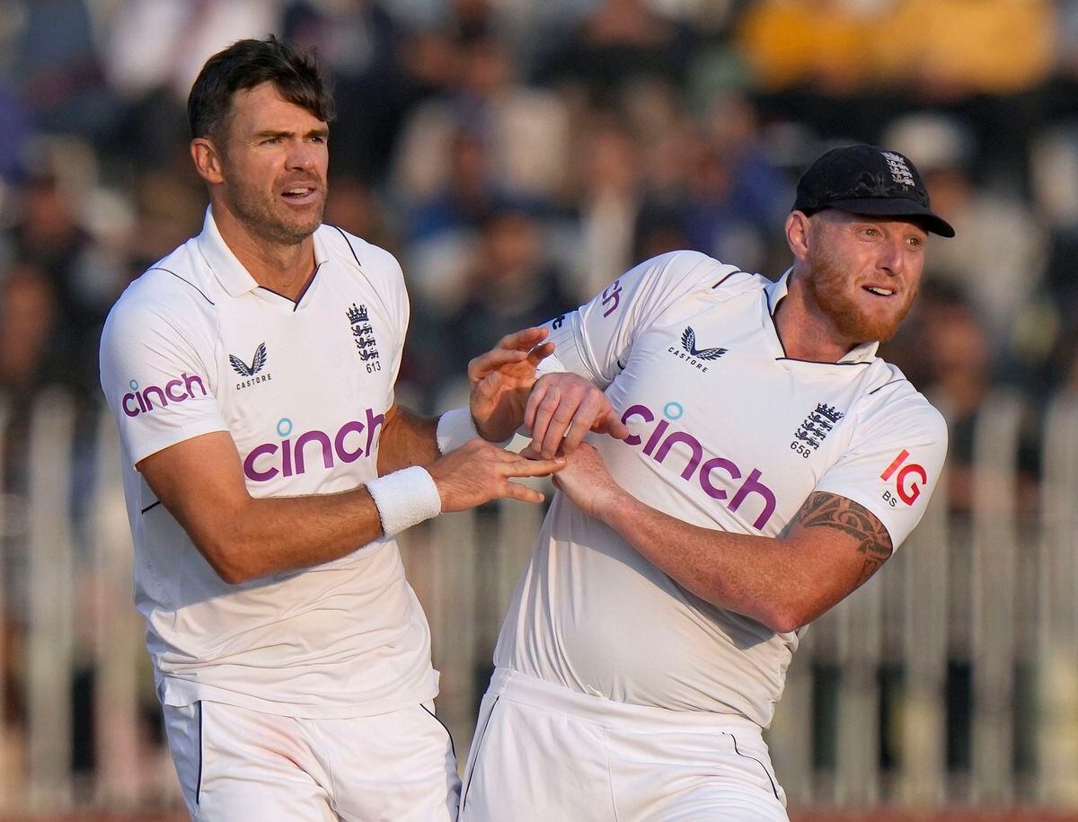 England's James Anderson, center, and Ben Stokes celebrate after the dismissal of Pakistan's Zahid Mahmood during the fifth day of the first test cricket match between Pakistan and England, in Rawalpindi, Pakistan, Monday, Dec. 5, 2022. (AP Photo/Anjum Naveed).