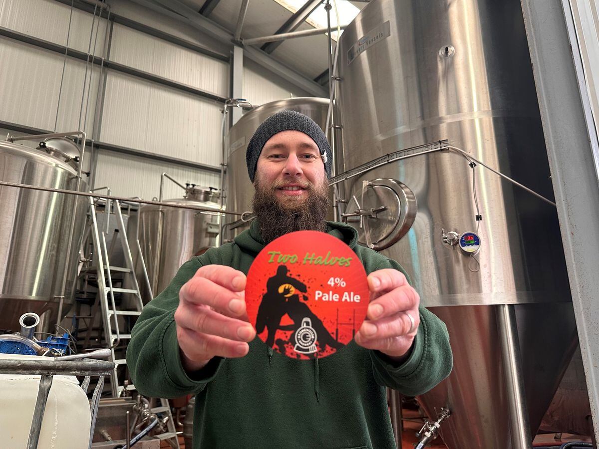 Dave Muir, head brewer, holding the beer badge