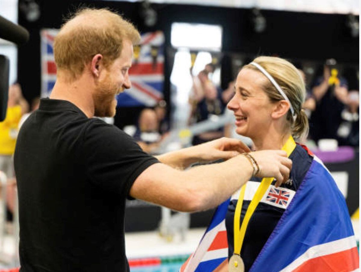 Kelly being presented with one of her silver medals by Prince Harry.