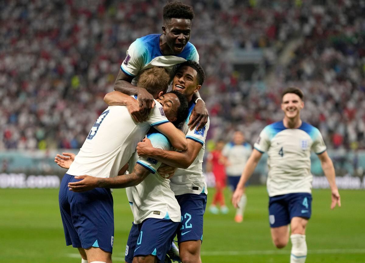 England's Raheem Sterling celebrates with teammates after scoring his side's third goal during the World Cup group B soccer match between England and Iran at the Khalifa International Stadium in Doha, Qatar, Monday, Nov. 21, 2022. (AP Photo/Frank Augstein).