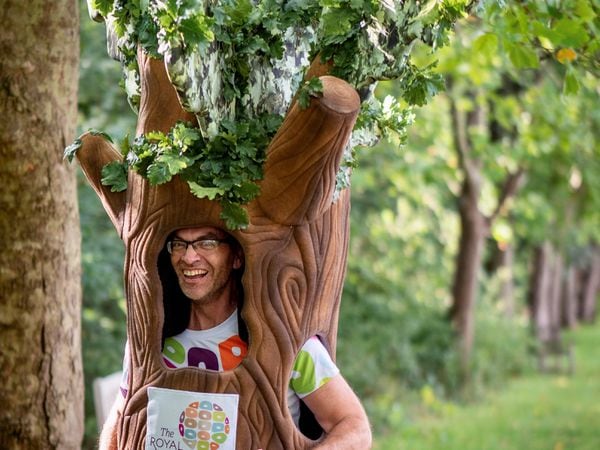 Man running in a tree outfit and smiling