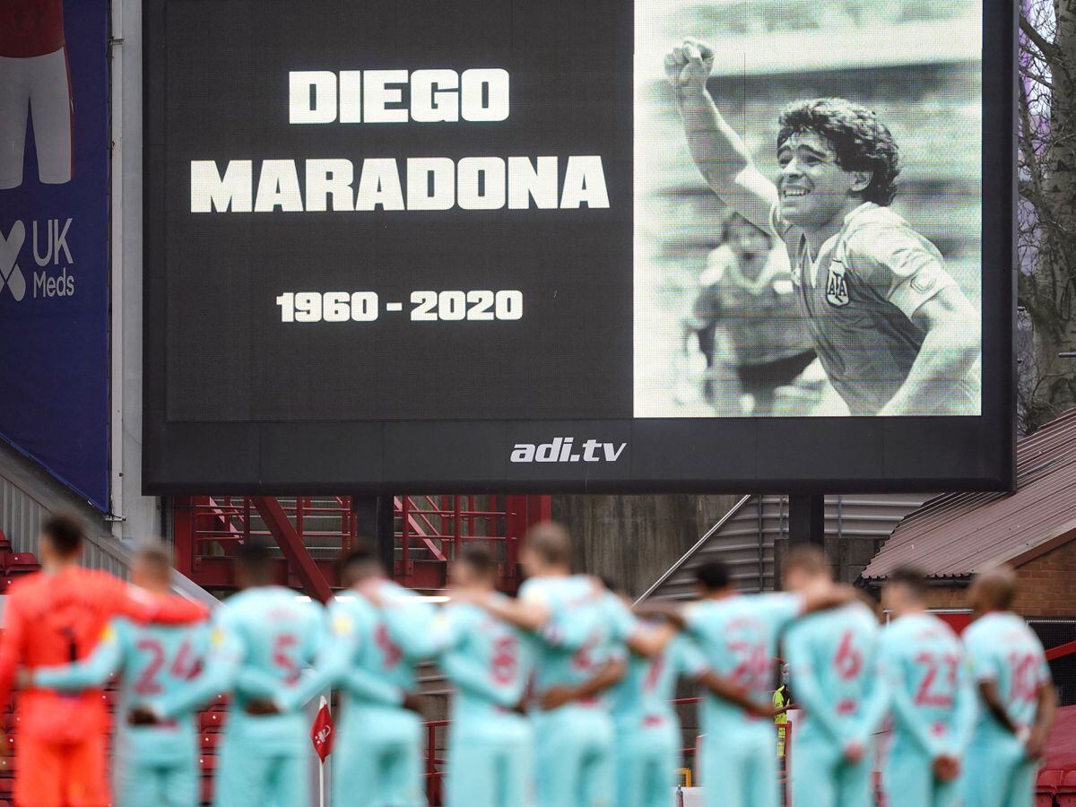 Players stand for a minutes silence in remembrance of Diego Maradona before the Sky Bet Championship match at The City Ground, Nottingham