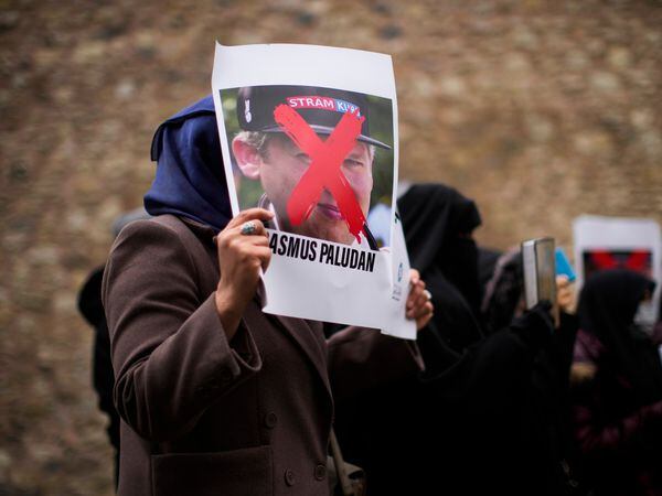 A woman holds a photo of far-right activist Rasmus Paludan during a protest outside the Swedish consulate in Istanbul