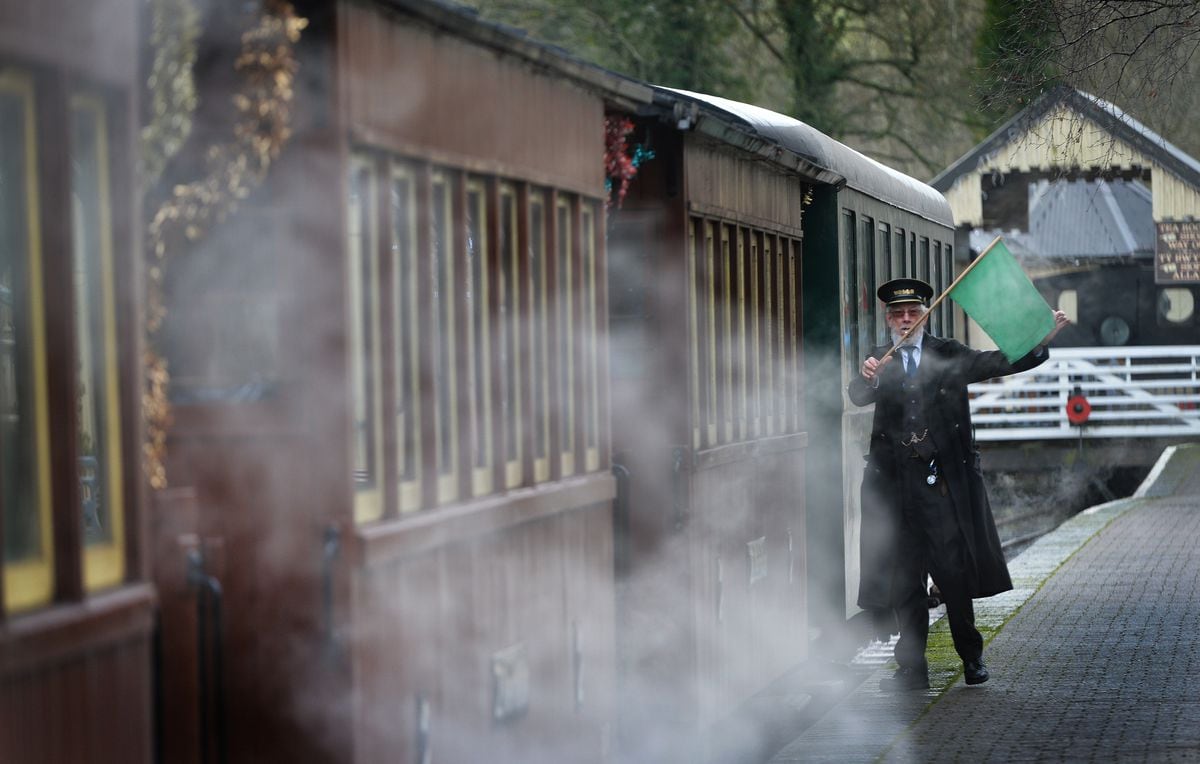 Guard Richard Wiltshire waves the train off the platform