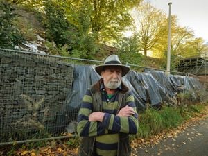 Councillor Andy Boddington next to a section of Ludlow town walls which collapsed a decade ago