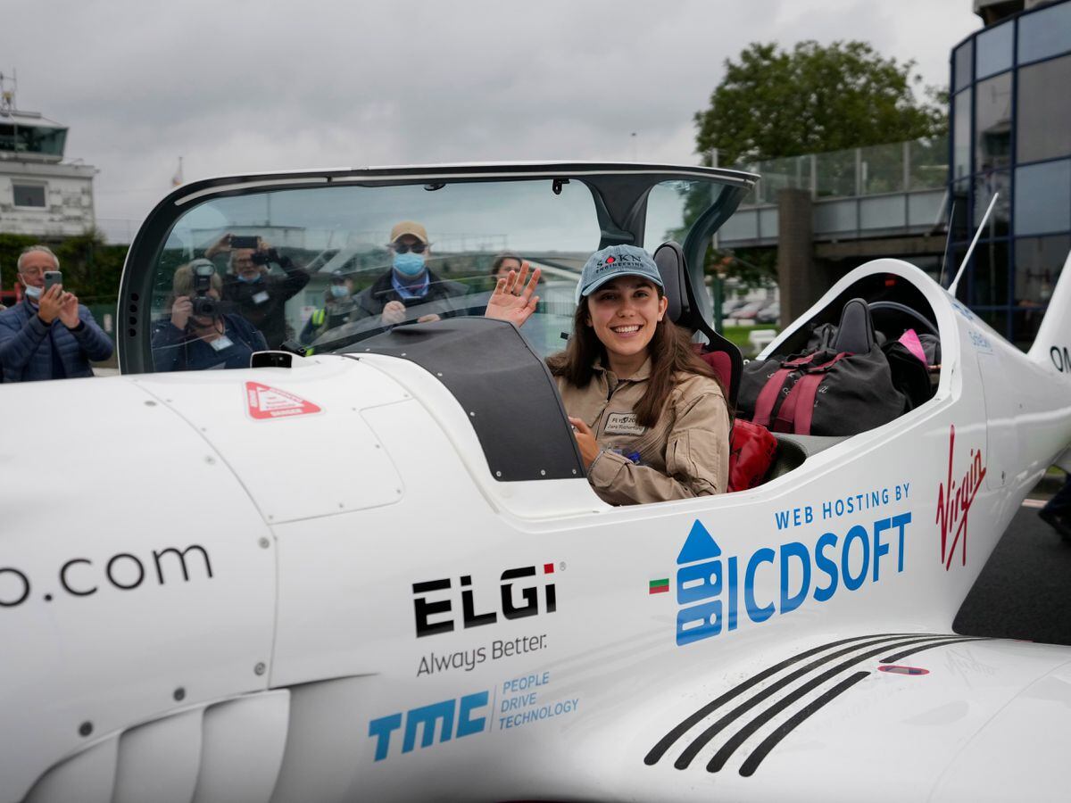 L'adolescente belgo-britannique Zara Rutherford salue de son avion ultraléger Shark avant le décollage à l'aérodrome de Kortrijk-Wevelgem à Wevelgem, Belgique