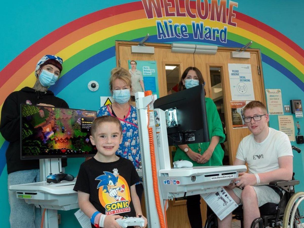 Pictured with the two new interactive gaming carts are, from left, Jess Miree from TheRockinR; Freddie Evans, 5, a patient on Alice Ward; Polly Brown, Health Play Specialist; Heather Thomas-Bache, Head of Fundraising, Communications and Volunteers for the League of Friends; and Joel Phillips,16, a patient on Alice Ward. 