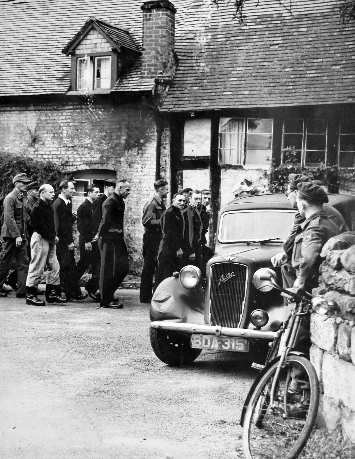British soldiers keep an eye out for fraternisation with villagers as prisoners of war make their way to church in Worfield in September 1946.