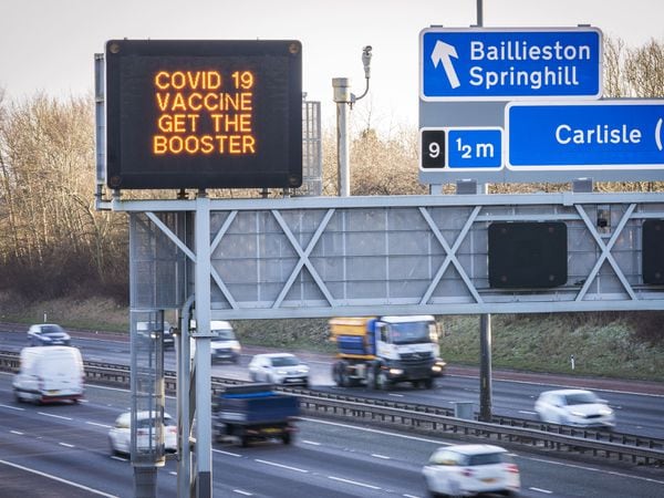 Information signs above the M8 motorway in Glasgow encourage people to get a Covid-19 booster jab (Jane Barlow/PA)