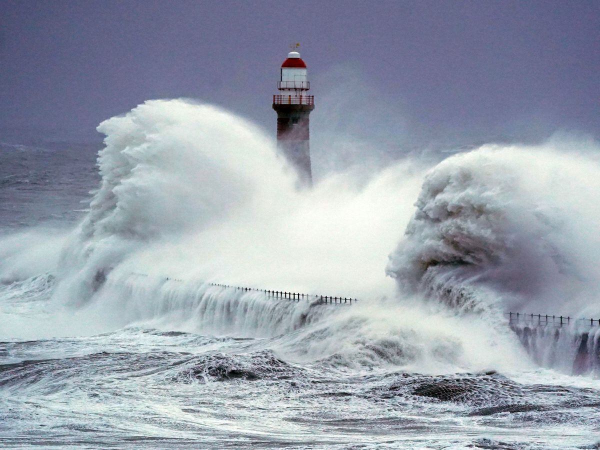 Huge waves crash the against the sea wall and Roker Lighthouse