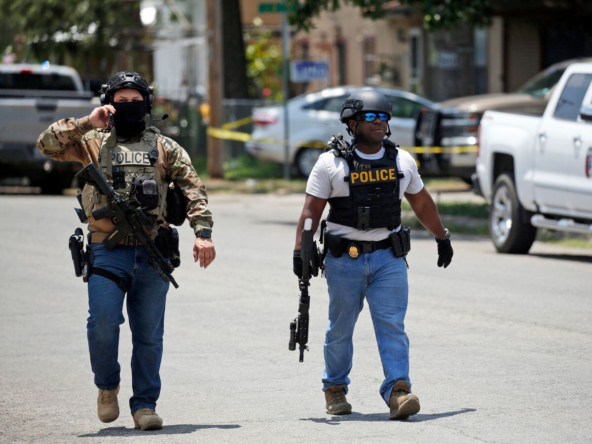 Police walk near Robb Elementary School following a shooting in Uvalde, Texas