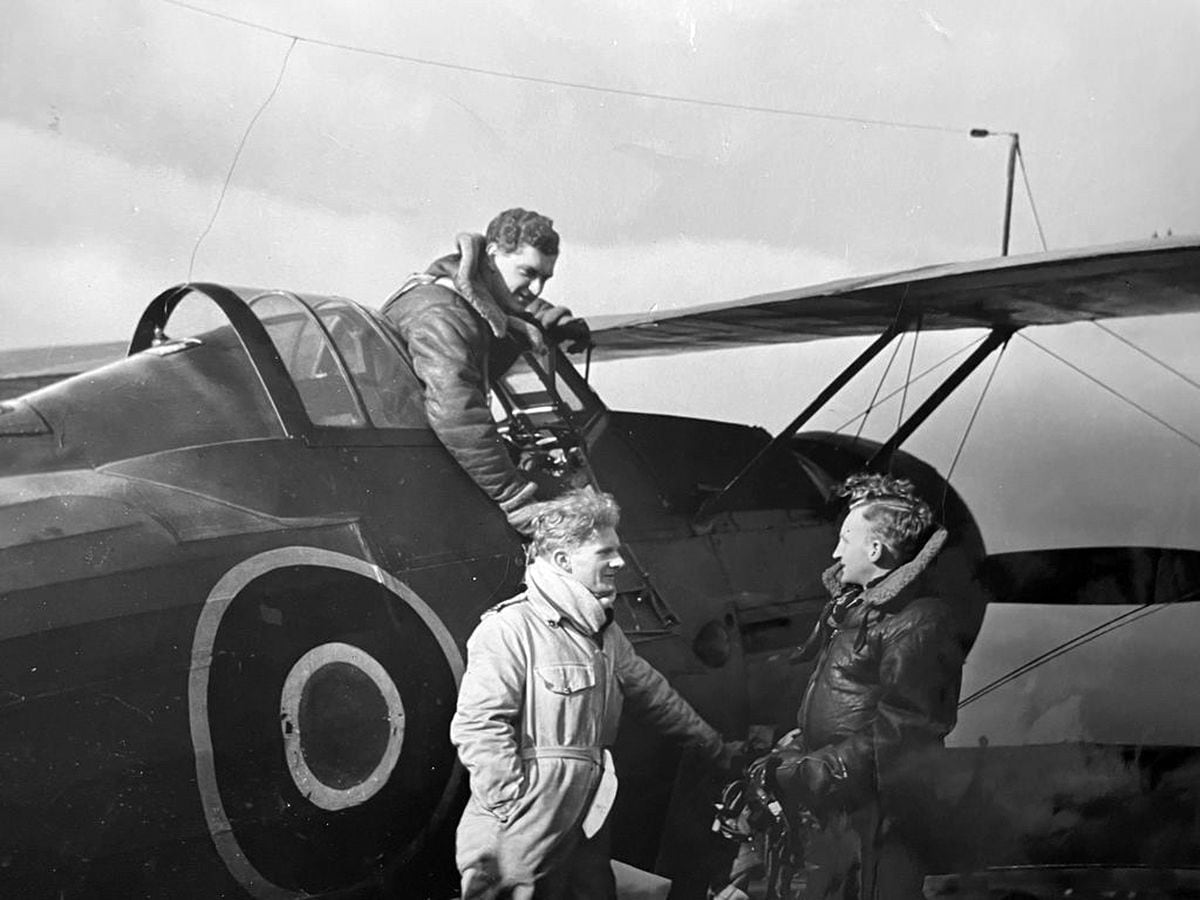 Peter Gordon-Hall – standing in the light overalls – at RAF Rednal in 1943 during the making of the movie. The aircraft is one of the Gloster Gladiator biplanes which were used.