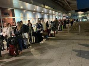 Passengers pictured queuing up outside Birmingham Airport