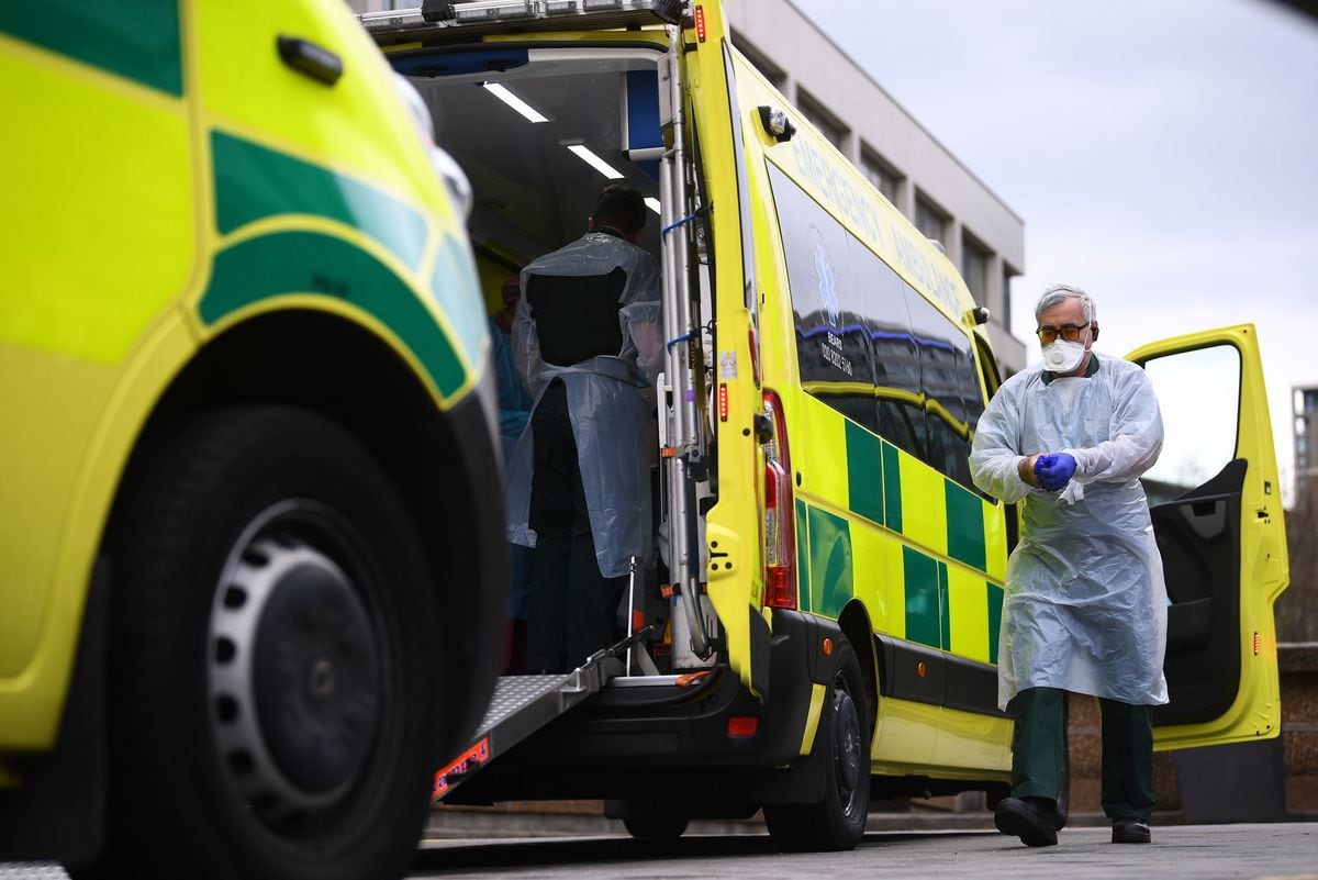 A paramedic wearing personal protective equipment exits an ambulance as the UK continues in lockdown to help curb the spread of the coronavirus