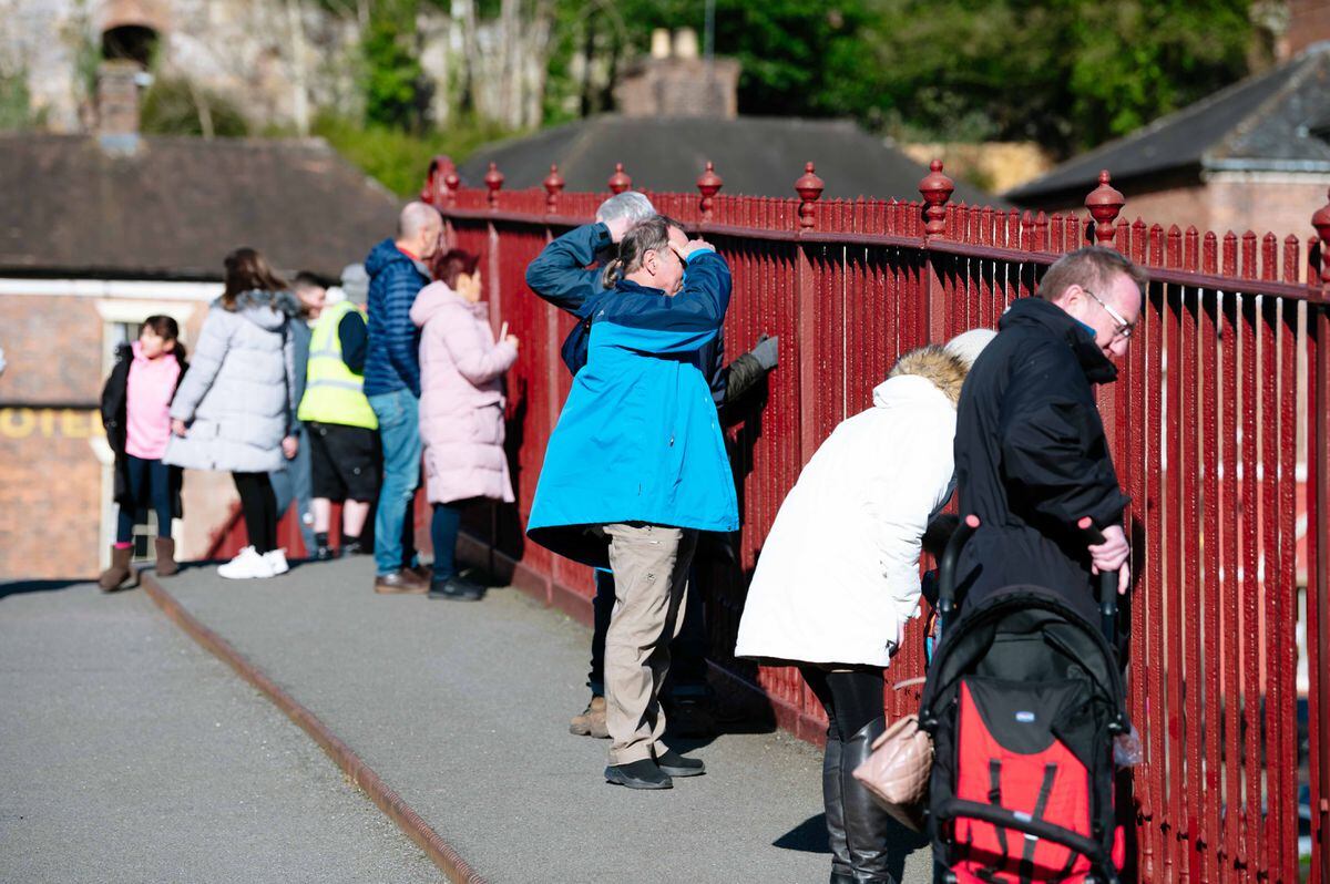 People watch the rising River Severn from the Iron Bridge