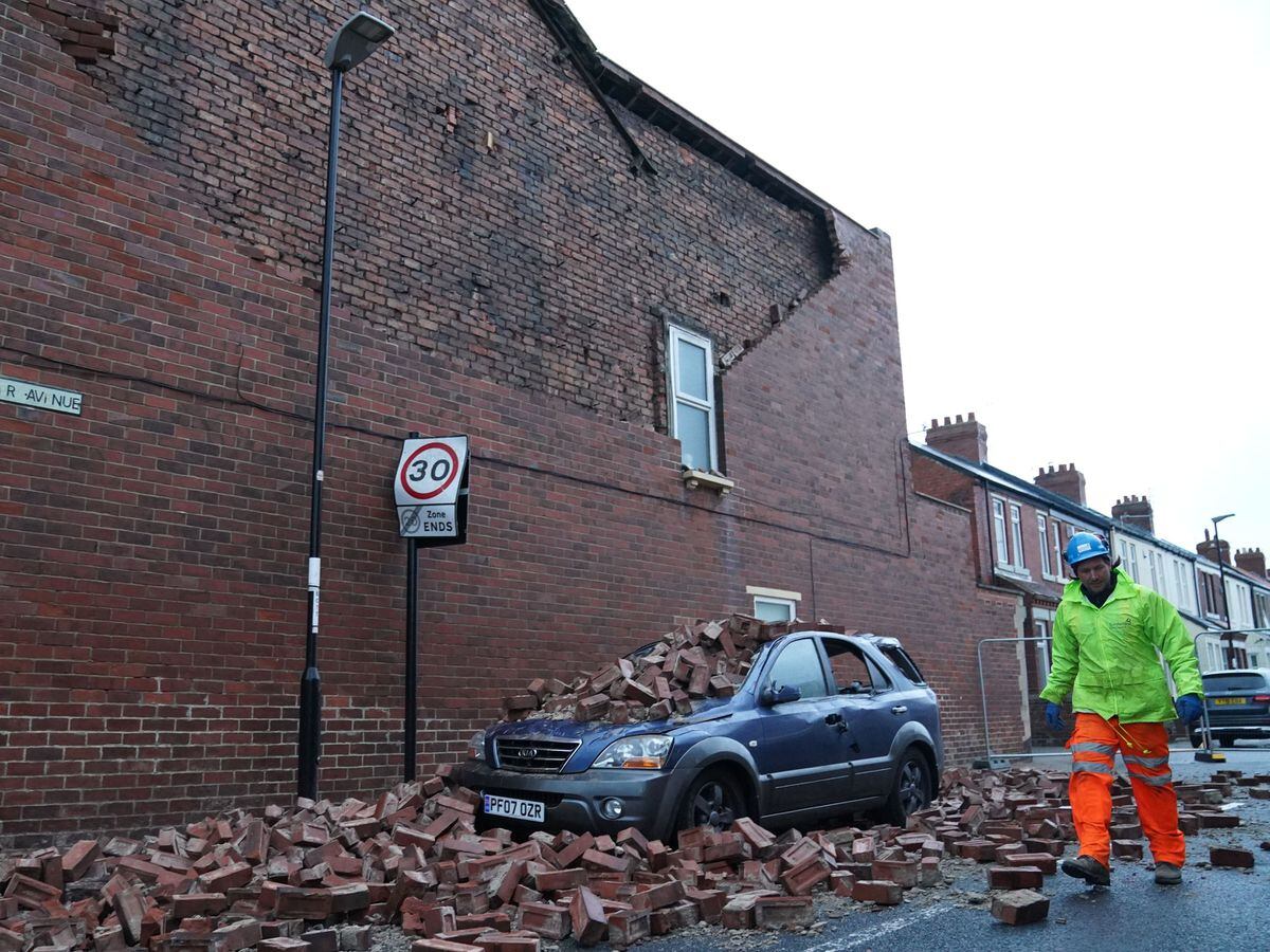 A man makes safe fallen masonry from a property, which has damaged a car in Roker, Sunderland