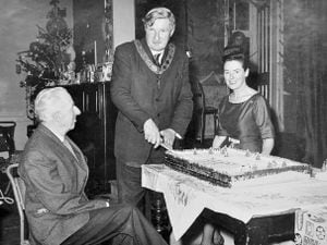 nostalgia pic. Wellington. Councillor Ernie Griffiths of Wellington cutting a cake. This is a print in the Shropshire Star picture archive and the only information with it is the copyright stamp on the back, which is for 'Fotorealm Photographers Ltd.' However, the person cutting the cake is identifiably Ernie Griffiths, a well known Wellington councillor for many years. He became chairman of Wellington Urban District Council in May 1965 for a year of office, so as he is wearing a chain of office a likely date for the picture is between May 1965 and May 1966 (unless he served more than one term). Wellington UDC. Other two and occasion remain to be identified. Note that the cake has little trees on, not sure what that signifies. Library code: Wellington nostalgia 2022..