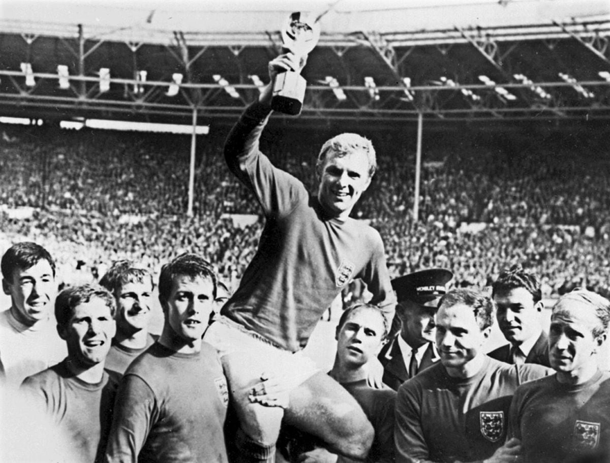 England captain Bobby Moore holds aloft the Jules Rimet trophy as he is carried by his teammates 