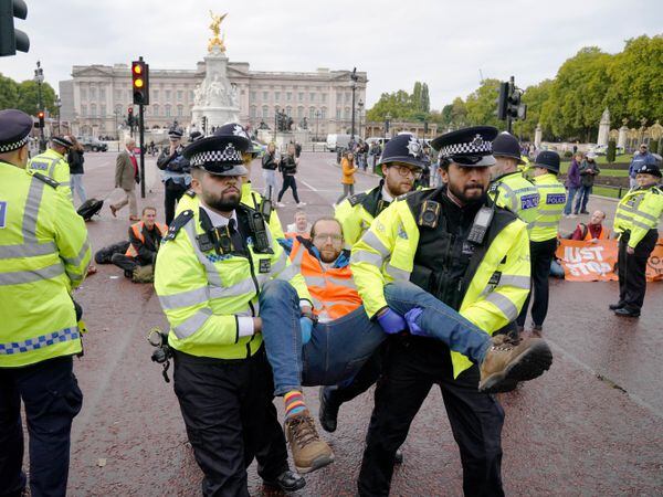 Police officers remove a campaigner from a Just Stop Oil protest