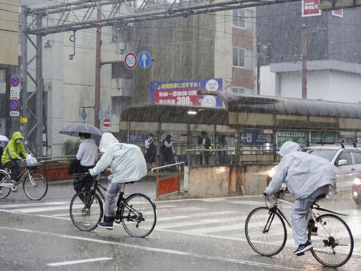 People make their way in strong rain in Kochi, southern Japan