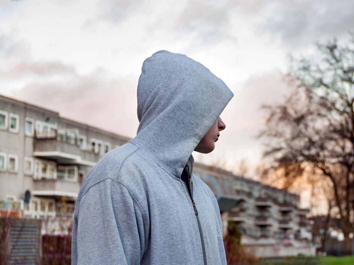 Teenager hanging around wearing hoodie top, London, UK
