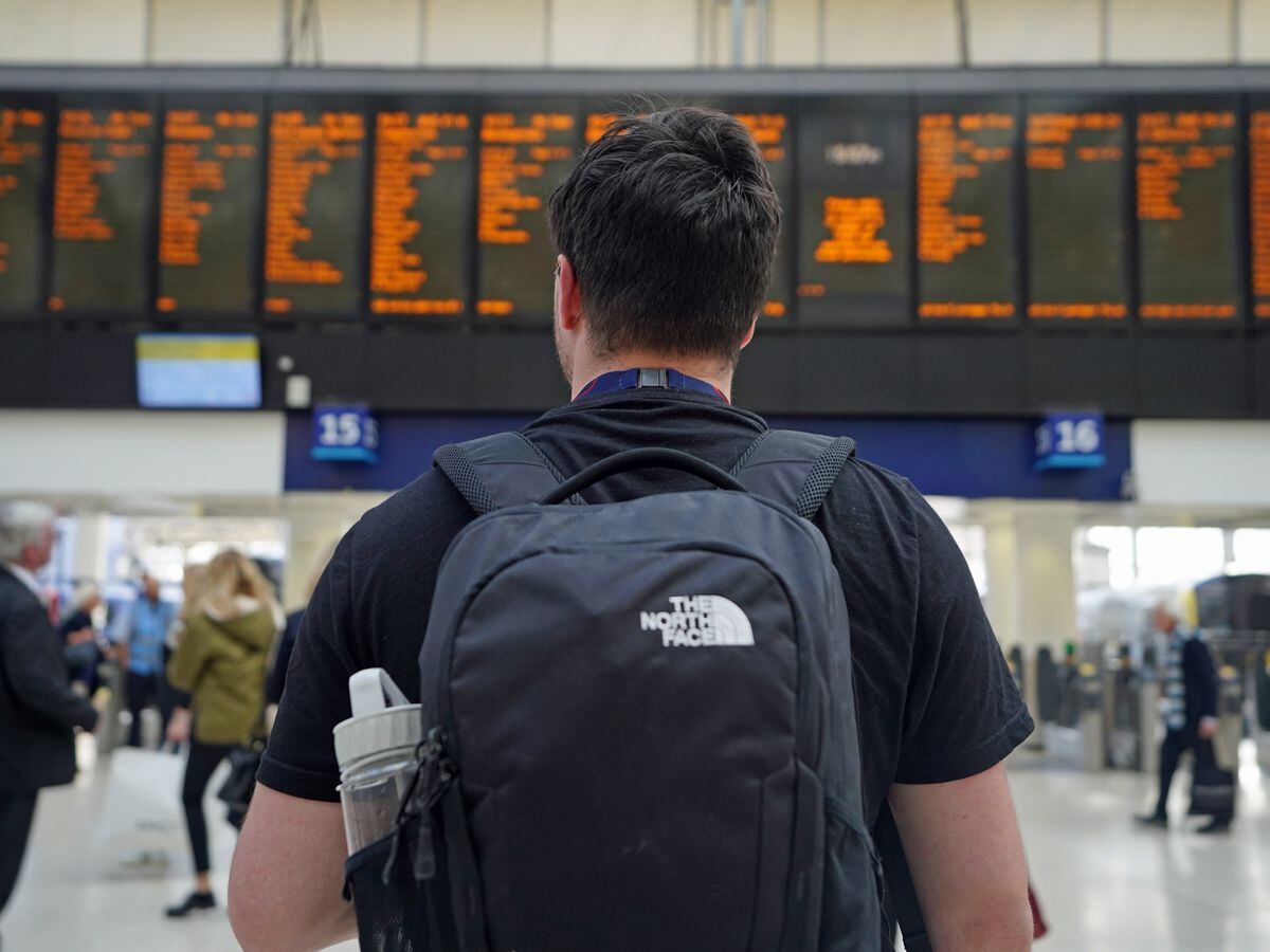 A passenger looks at departures boards at London Waterloo station