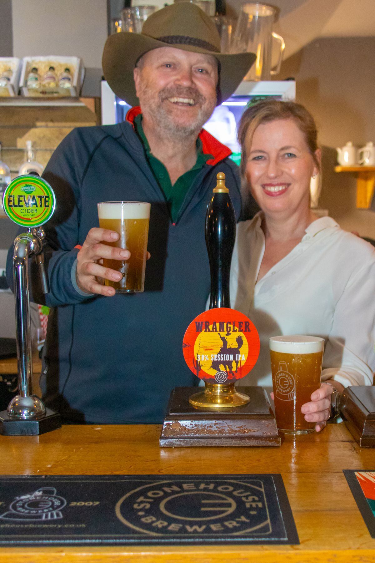 Alison and Shane Parr enjoying a freshly poured pint of Wrangler to celebrate their success, behind the bar of the Stonehouse Brewery Tap House