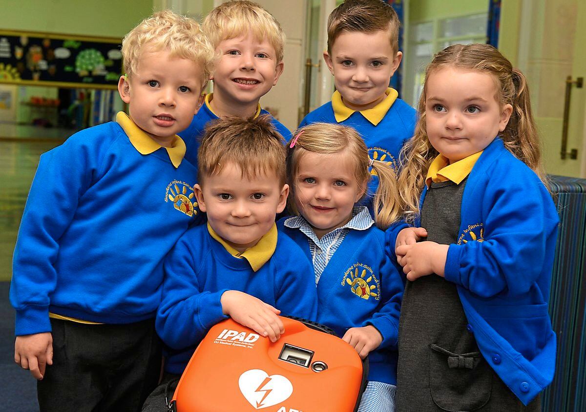 Youngsters Billy Lowe and Willow Doster hold the defibribillator as their classmates at Sundorne Infants and Nursery look on 