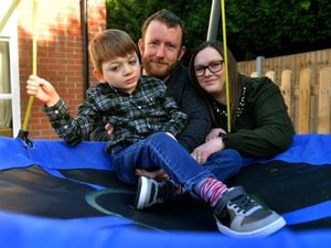 Eddie Irommonger 8, with his parents Mark and Emma Ironmonger. They are fundraising for a operation for Eddie who has cerebral palsy. Pictured on his swing in the garden in Hadley