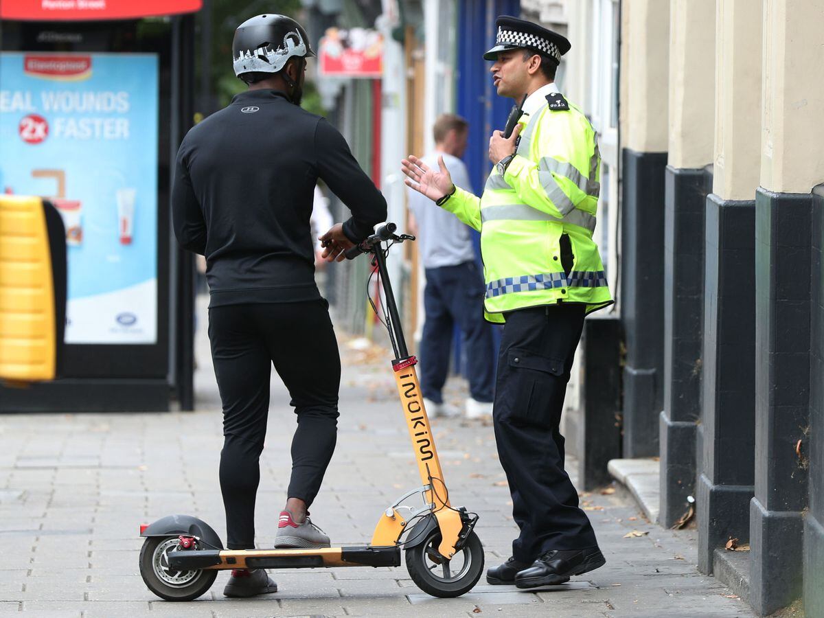 A police officer speaks to a private e-scooter rider